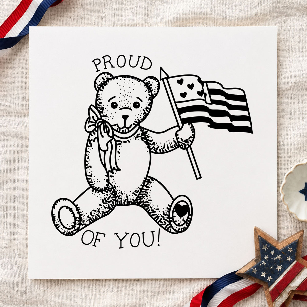 Proud of You Flag Bear Rubber Stamp Small impression in black ink on white paper in a styled craft setting.