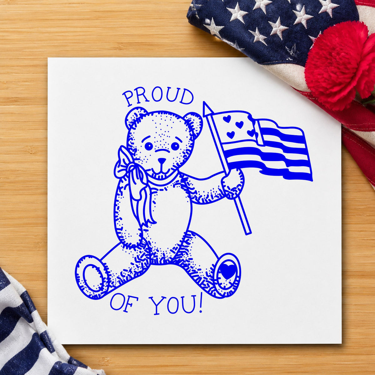 Proud of You Flag Bear Rubber Stamp Small impression in blue ink on white paper in a styled craft setting.