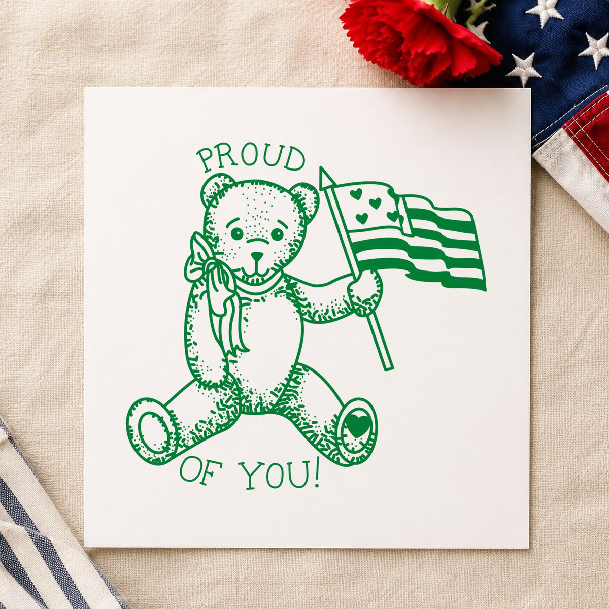 Proud of You Flag Bear Rubber Stamp Small impression in green ink on white paper in a styled craft setting.