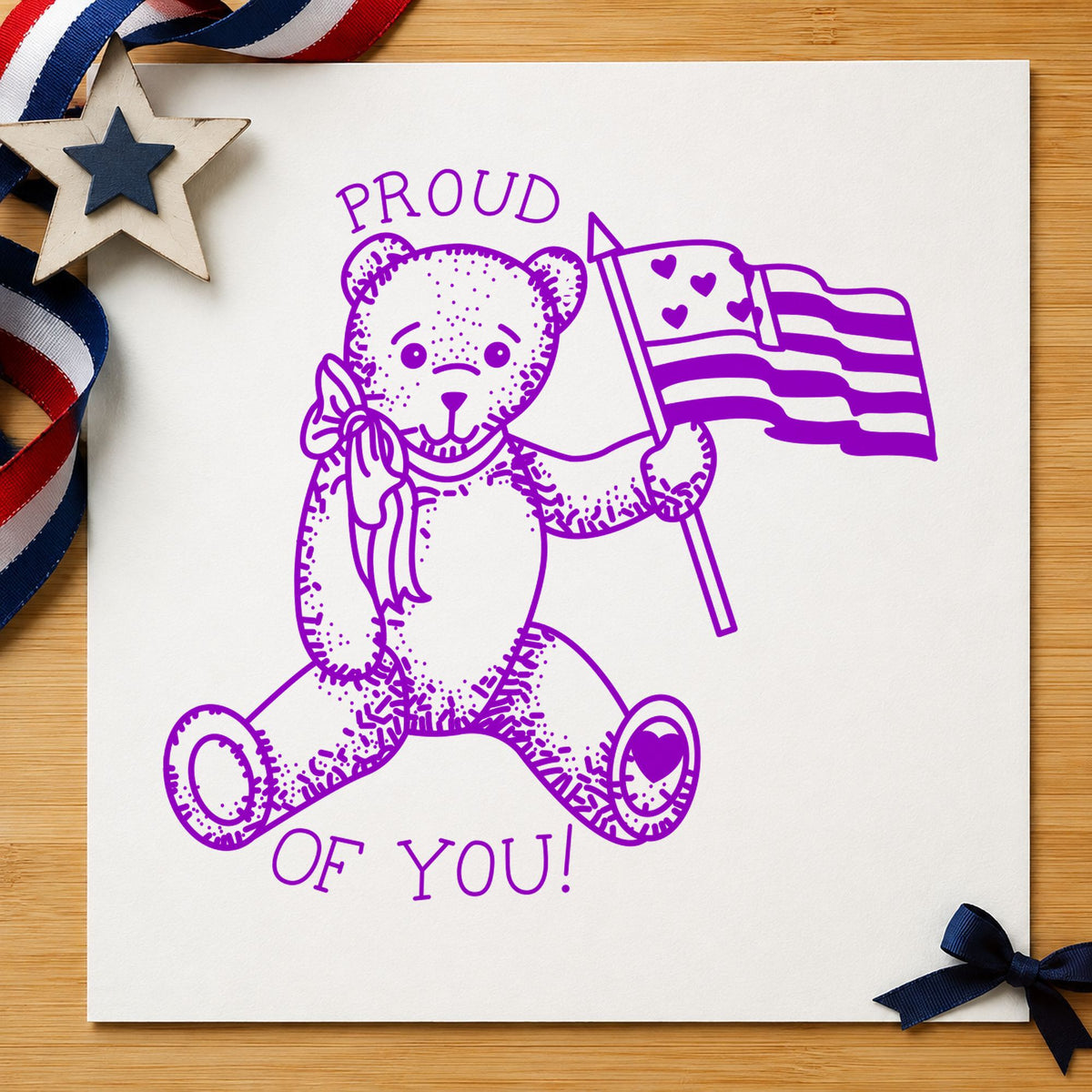 Proud of You Flag Bear Rubber Stamp Small impression in purple ink on white paper in a styled craft setting.