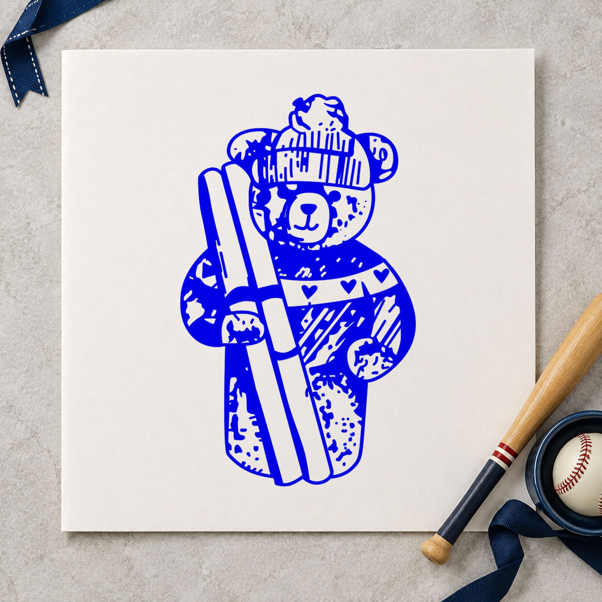 Ski Bear Holding Skis Rubber Stamp impression in blue ink on white paper in a styled craft setting.
