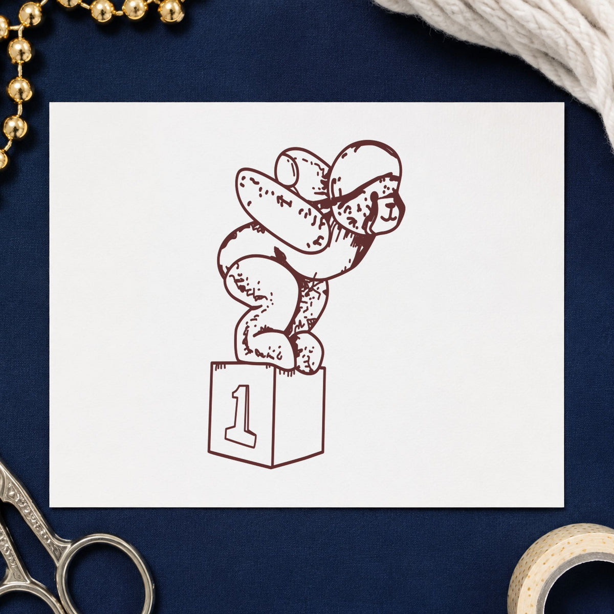 Diving Bear on Starting Block Rubber Stamp impression in brown ink on white paper in a styled craft setting.