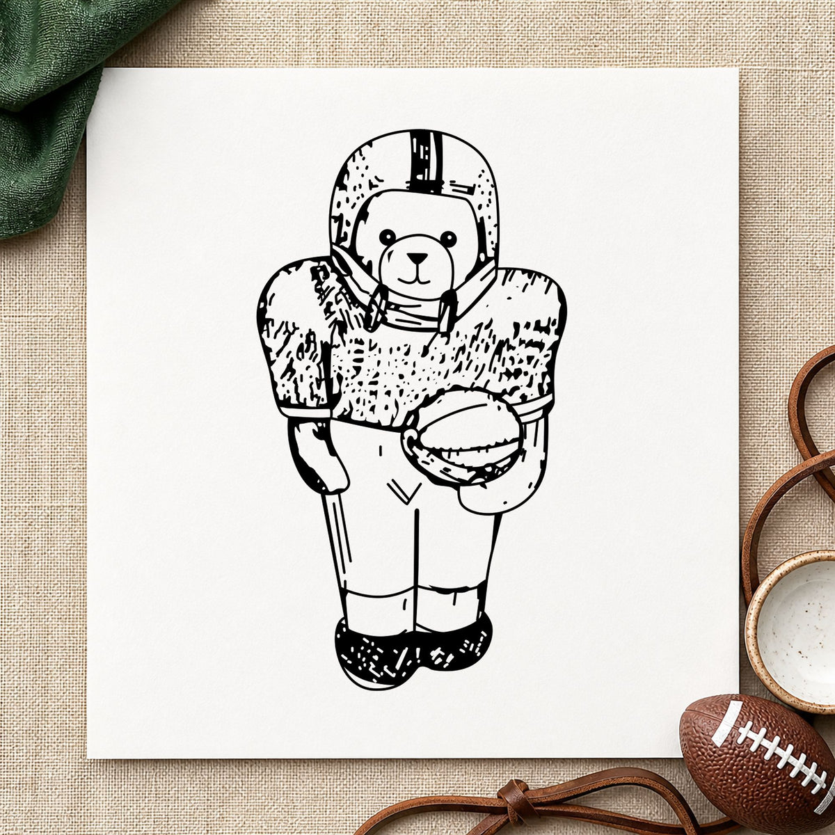 Black impression from a football rubber stamp, featuring the football bear in uniform design on white paper.