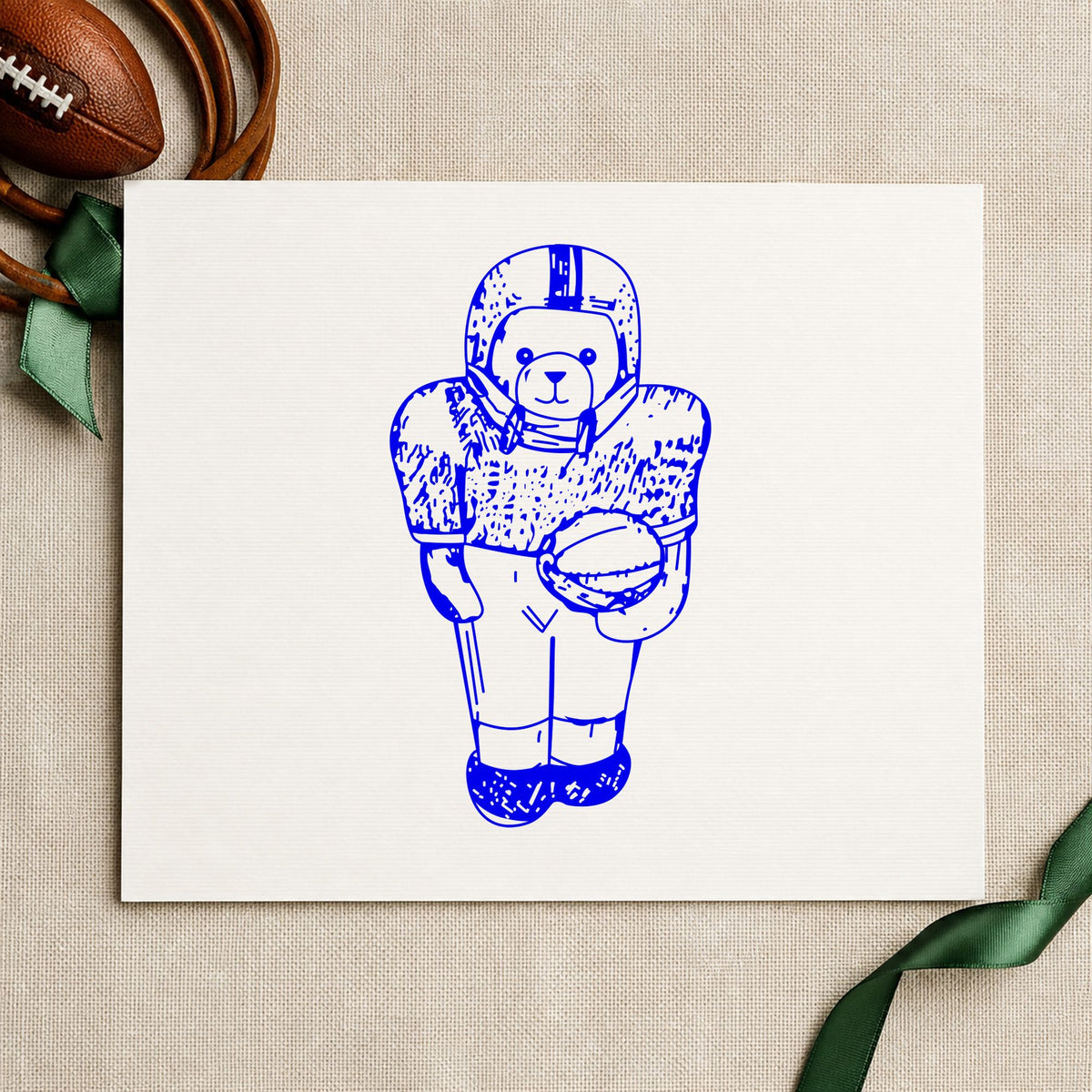 Football Bear in Uniform Rubber Stamp impression in blue ink on white paper in a styled craft setting.