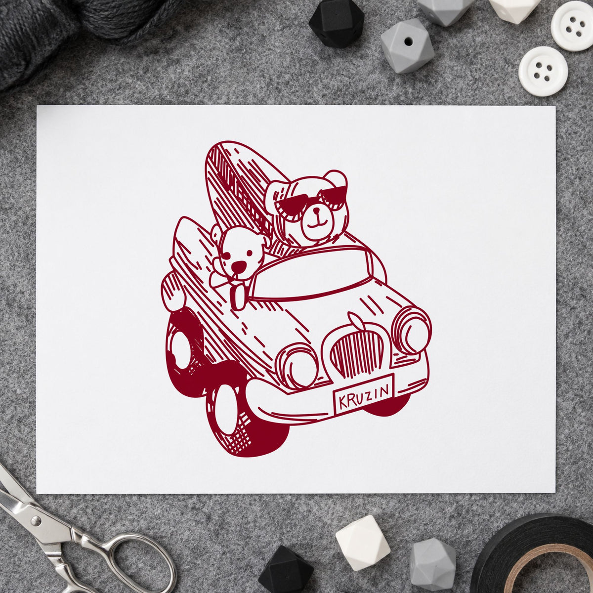 Surfboard Bear in Convertible Rubber Stamp impression in burgundy ink on white paper in a styled craft setting.