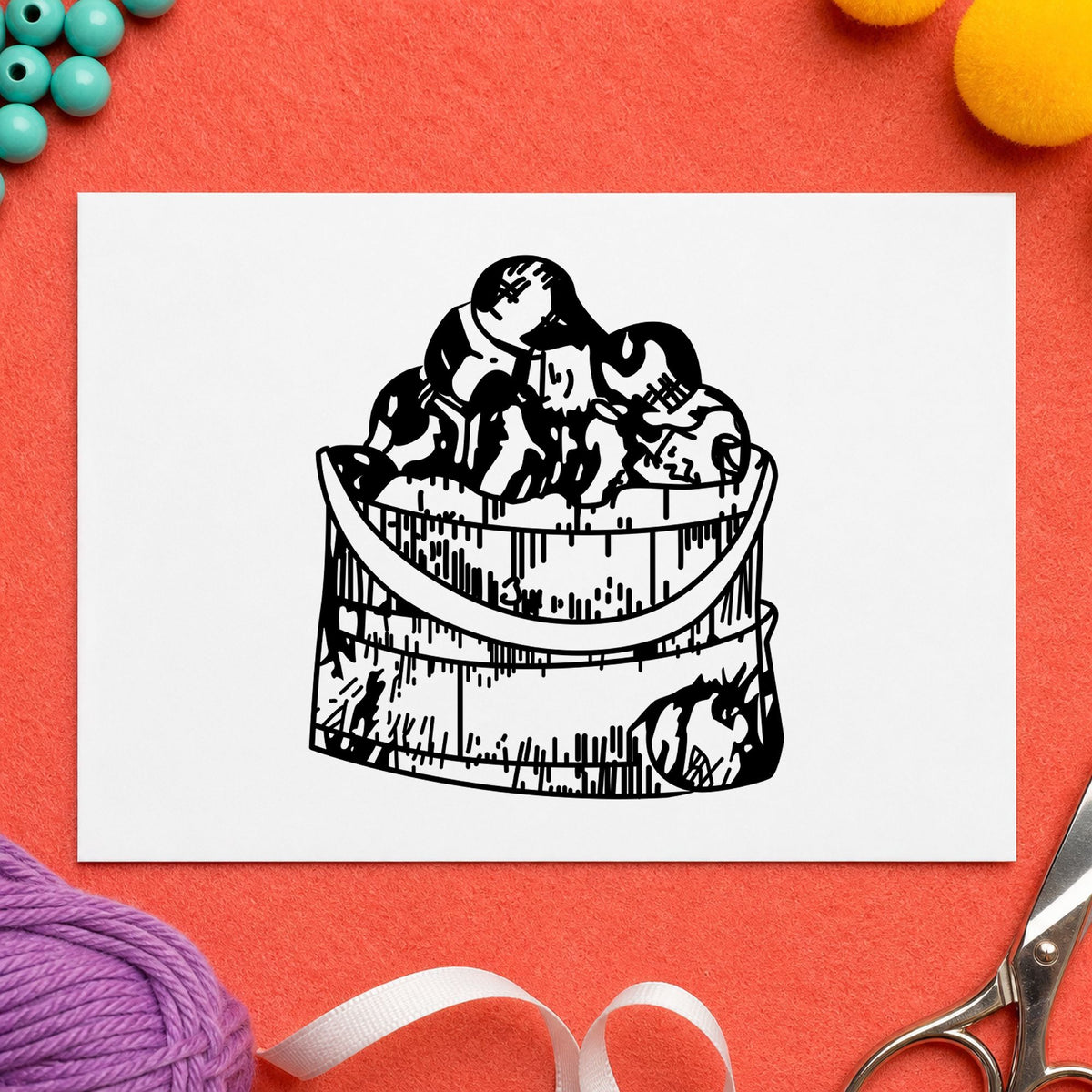 Wooden Bucket of Apples Rubber Stamp impression in black ink on white paper in a styled craft setting.