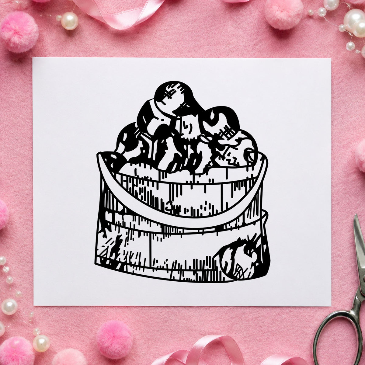 Black impression from a apple rubber stamp, featuring the wooden bucket of apples design on white paper.