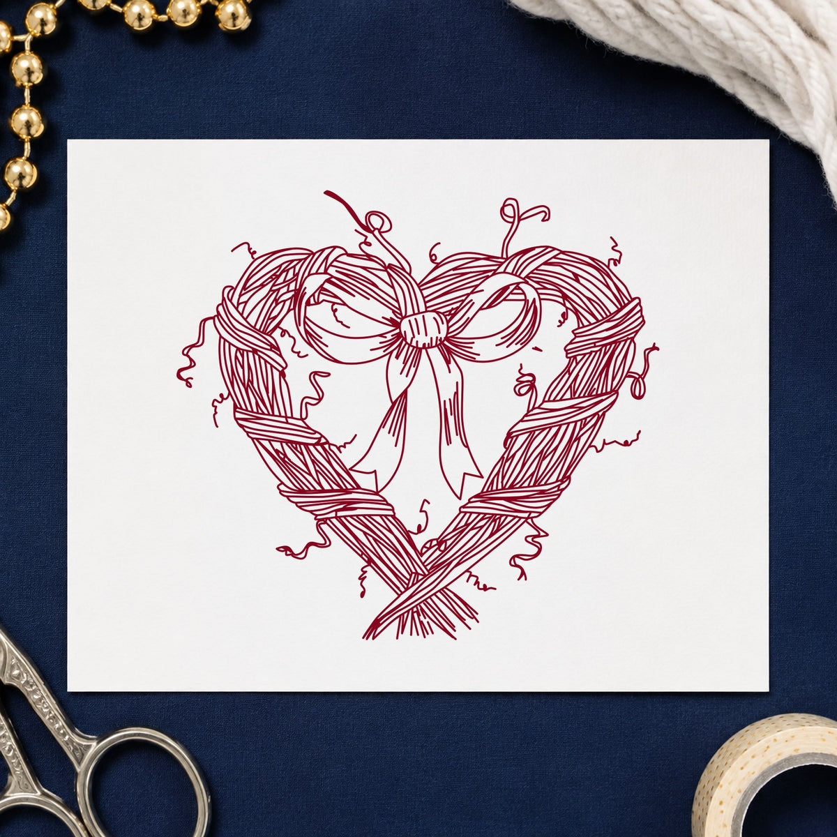 Heart Wreath with Bow Rubber Stamp impression in burgundy ink on white paper in a styled craft setting.