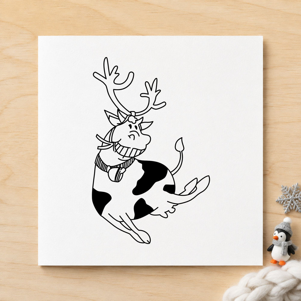 Black impression from a christmas cow stamp, featuring the leaping cow with reindeer antlers design on white paper.