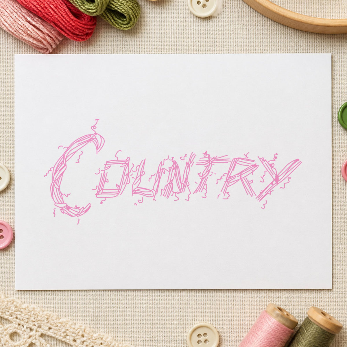 Country Lettering Rubber Stamp impression in pink ink on white paper in a styled craft setting.