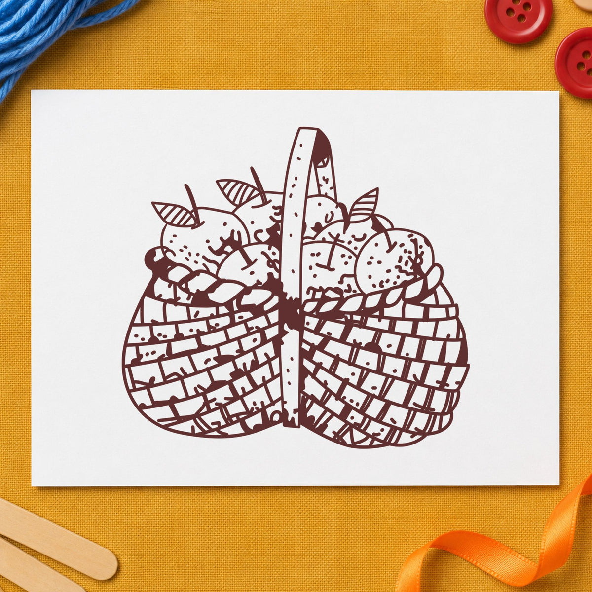 Basket Brimming with Apples Rubber Stamp impression in brown ink on white paper in a styled craft setting.