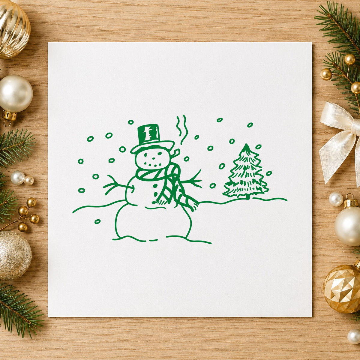 Snowman in Winter Landscape Rubber Stamp impression in green ink on white paper in a styled craft setting.
