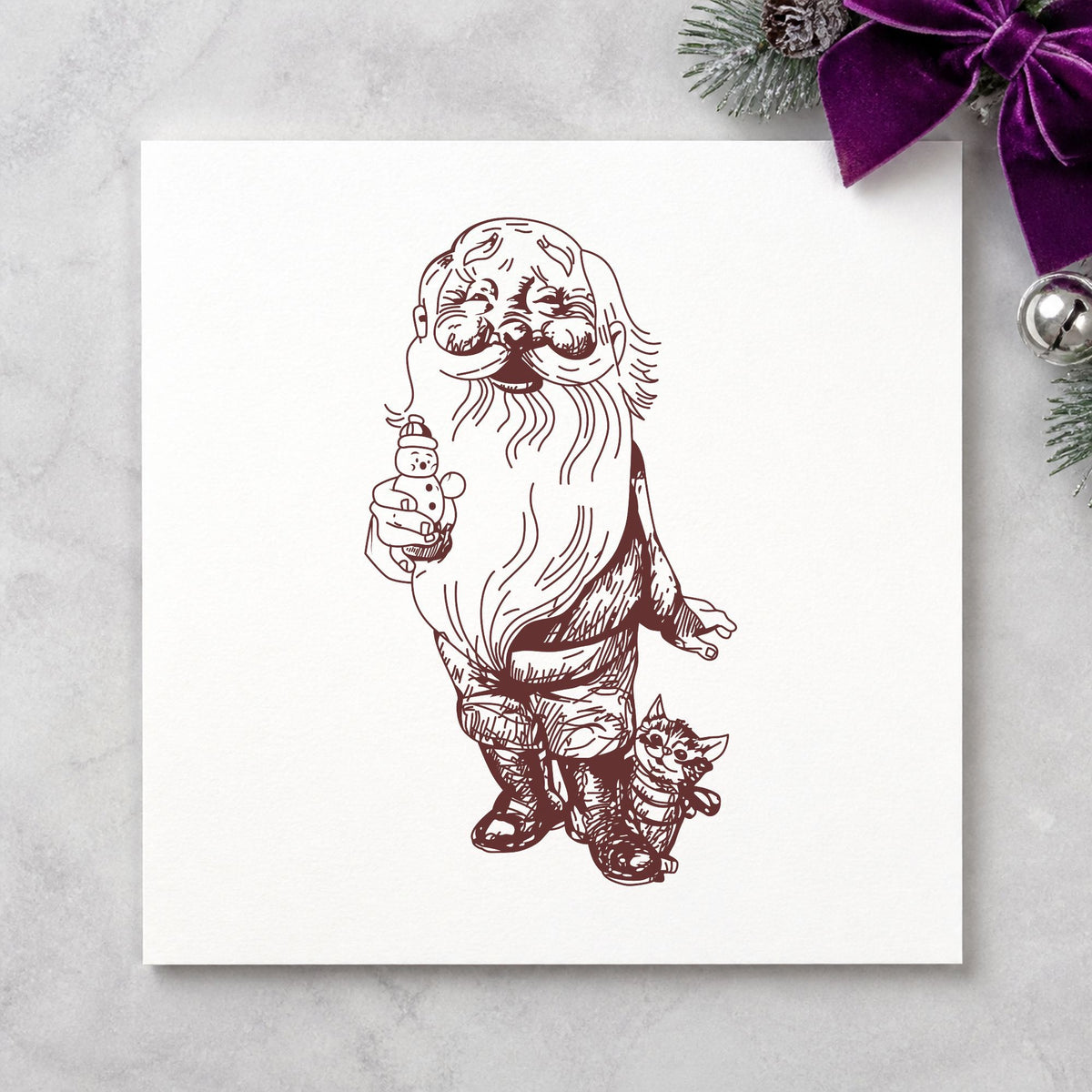 Santa with Kitten and Snowman Rubber Stamp impression in brown ink on white paper in a styled craft setting.