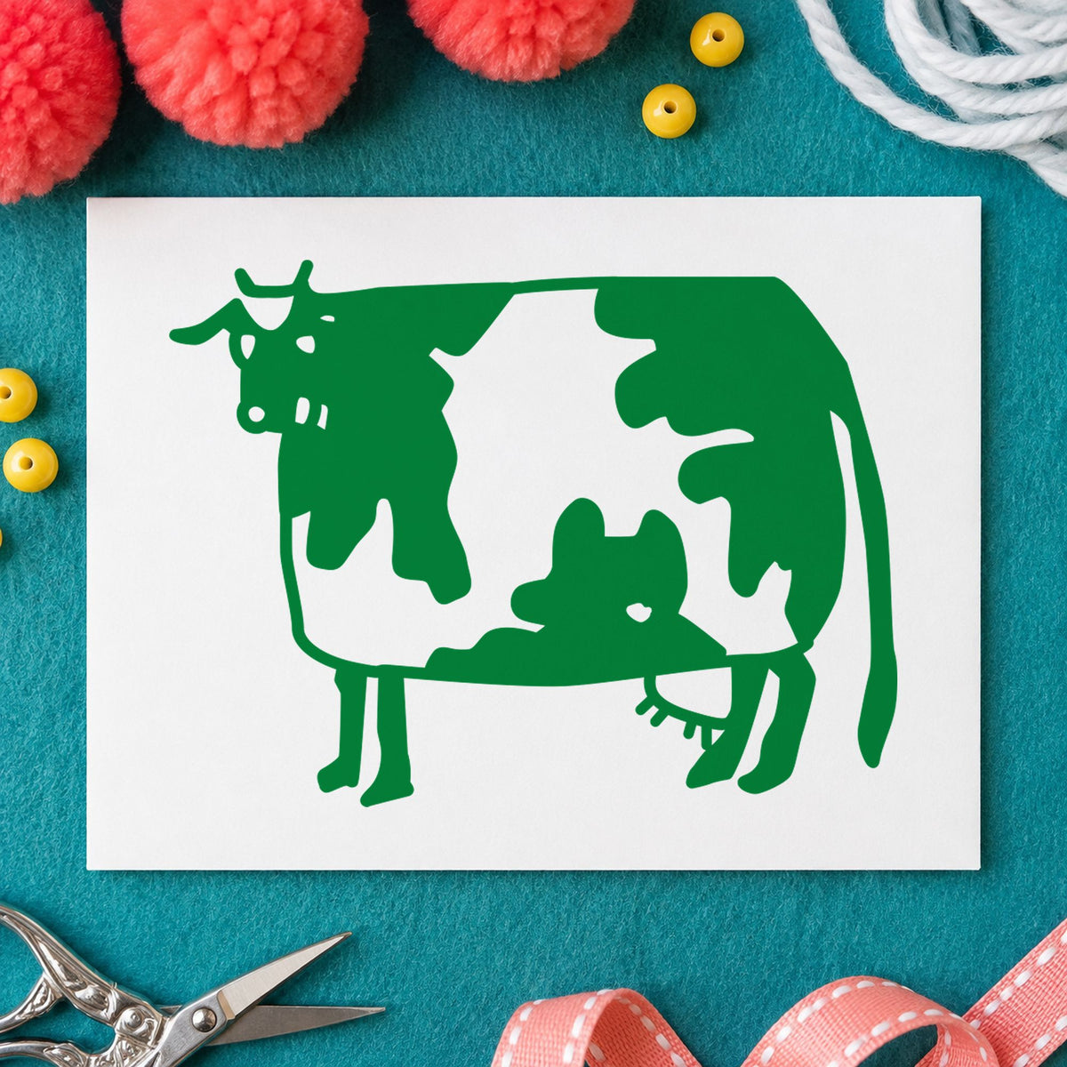 Folk Art Cow Rubber Stamp impression in green ink on white paper in a styled craft setting.