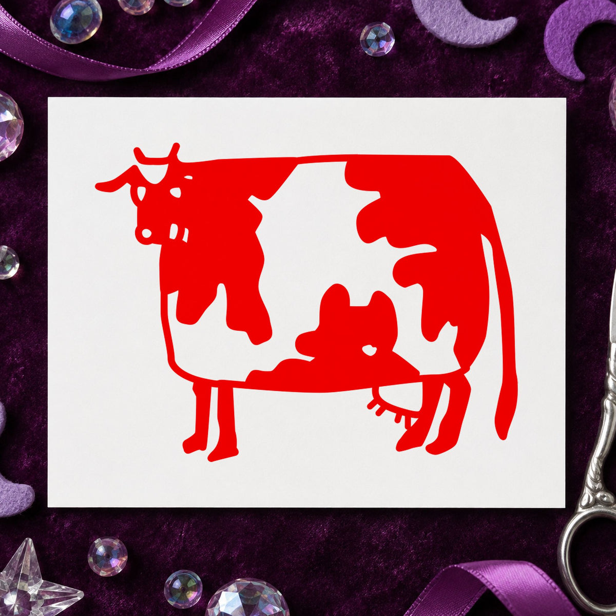 Folk Art Cow Rubber Stamp impression in red ink on white paper in a styled craft setting.
