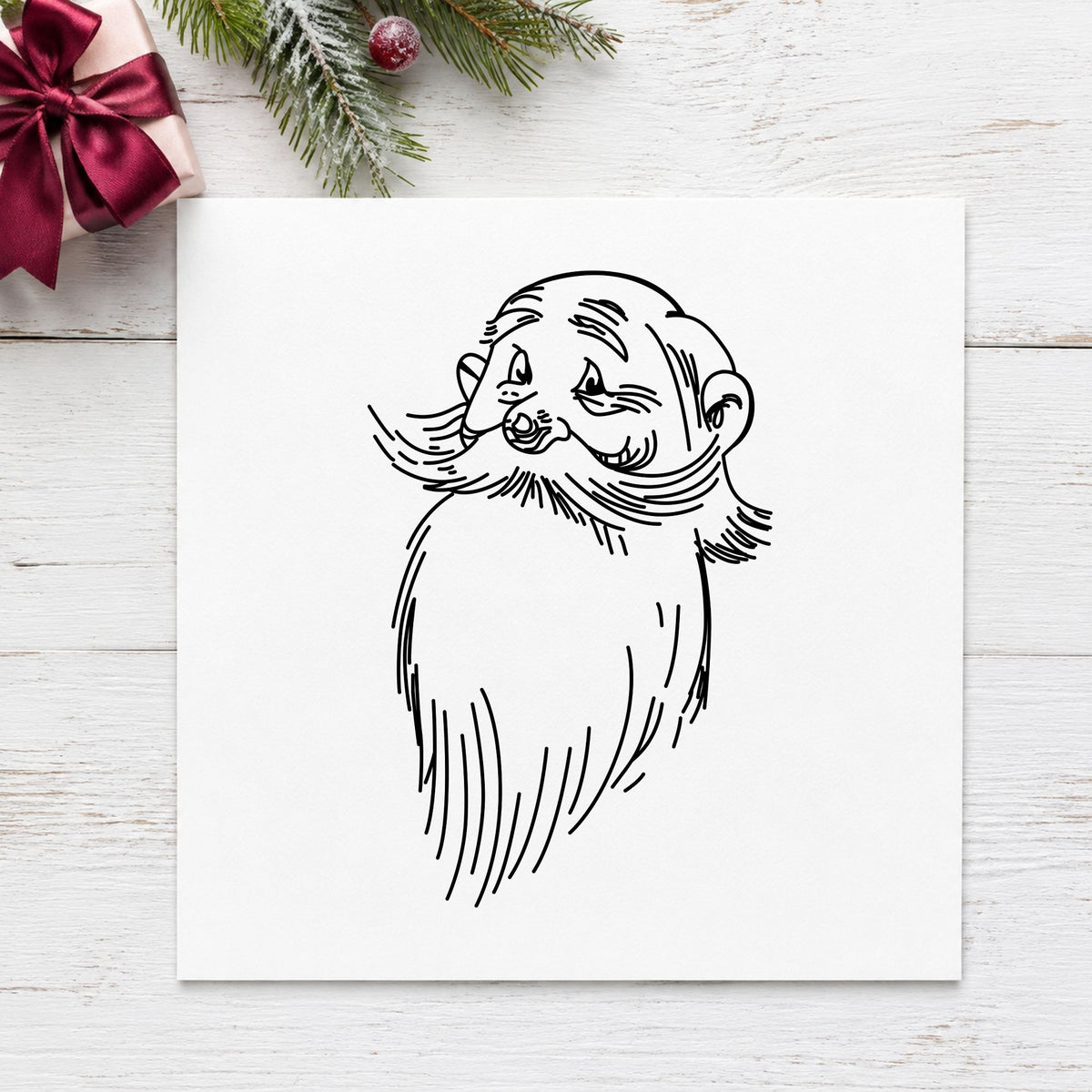 Santa Claus Face Rubber Stamp impression in black ink on white paper in a styled craft setting.