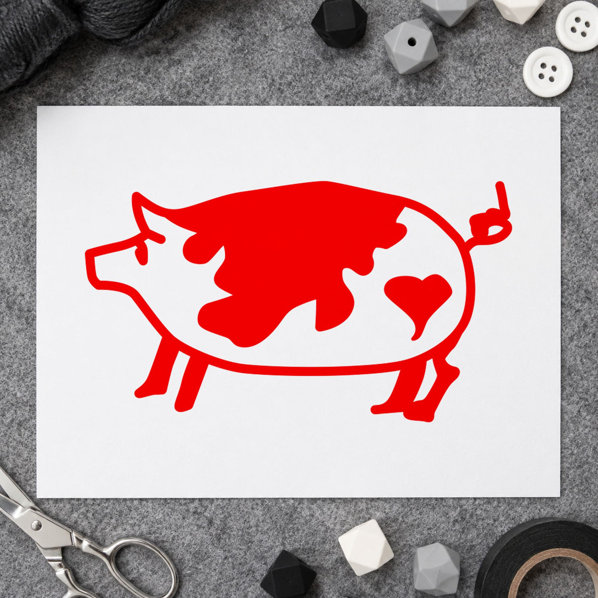 Spotted Pig with Heart Rubber Stamp impression in red ink on white paper in a styled craft setting.