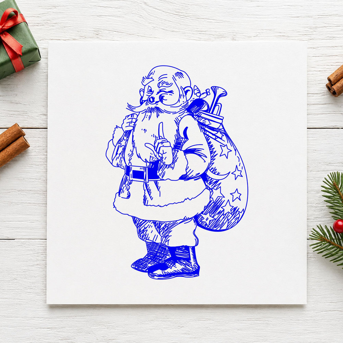 Blue christmas card making stamp impression featuring the santa with gift sack design on white paper.