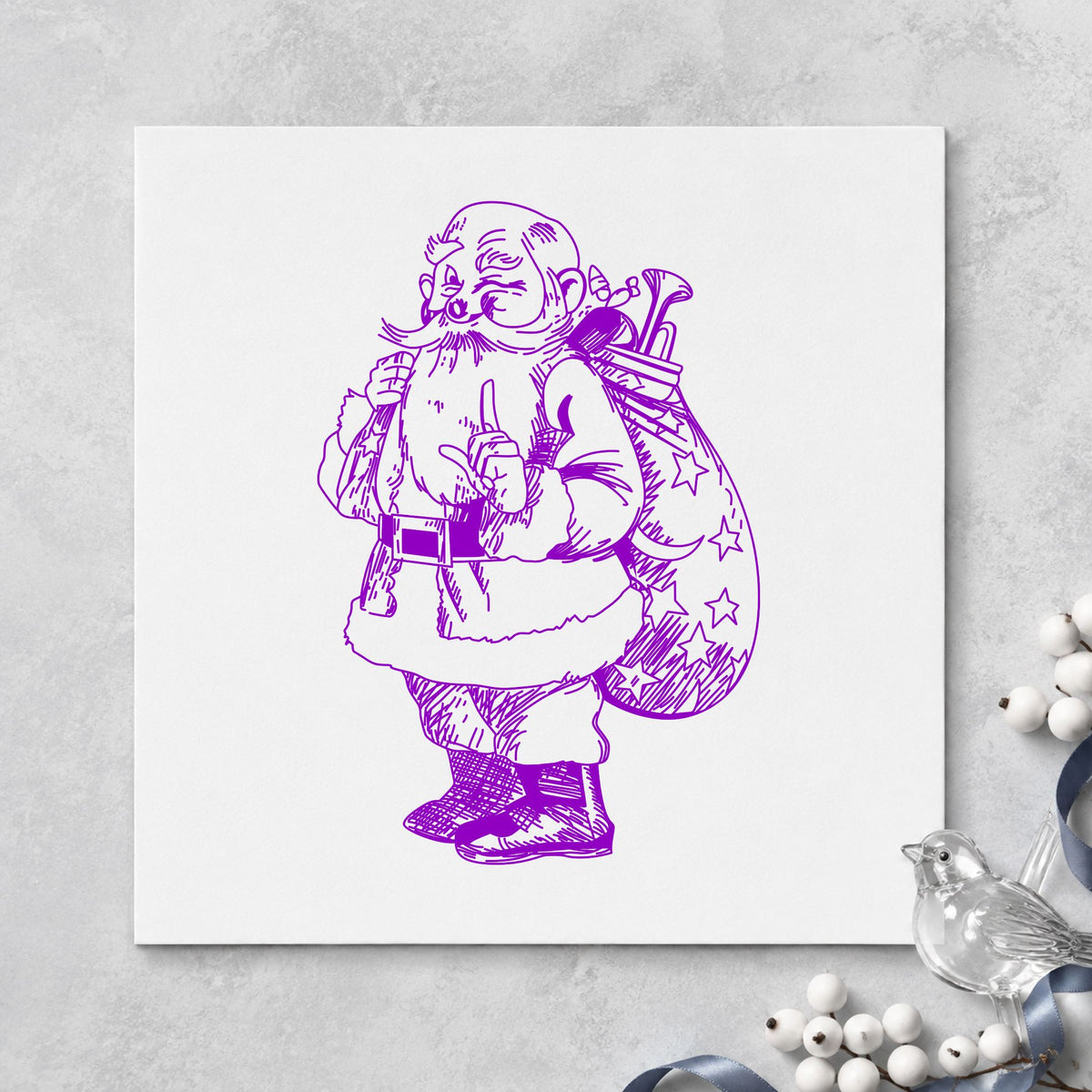 Santa with Gift Sack Rubber Stamp impression in purple ink on white paper in a styled craft setting.