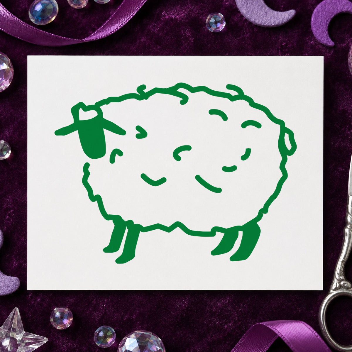 Folk Art Sheep Rubber Stamp impression in green ink on white paper in a styled craft setting.