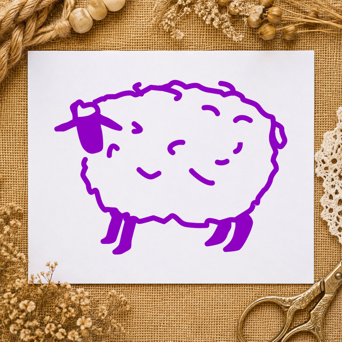 Folk Art Sheep Rubber Stamp impression in purple ink on white paper in a styled craft setting.