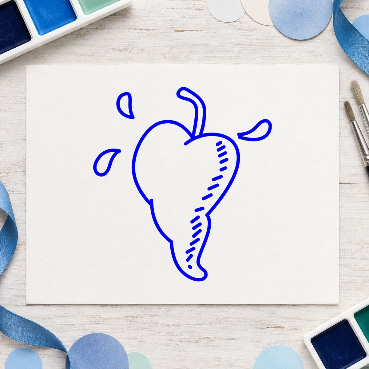 Blue valentine craft stamp impression featuring the heart-shaped pepper design on white paper.