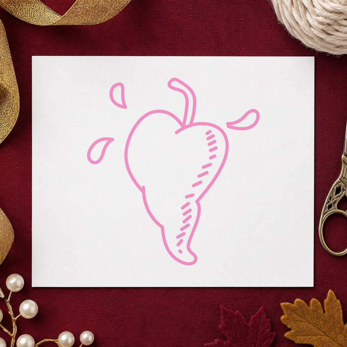 Heart-shaped Pepper Rubber Stamp impression in pink ink on white paper in a styled craft setting.