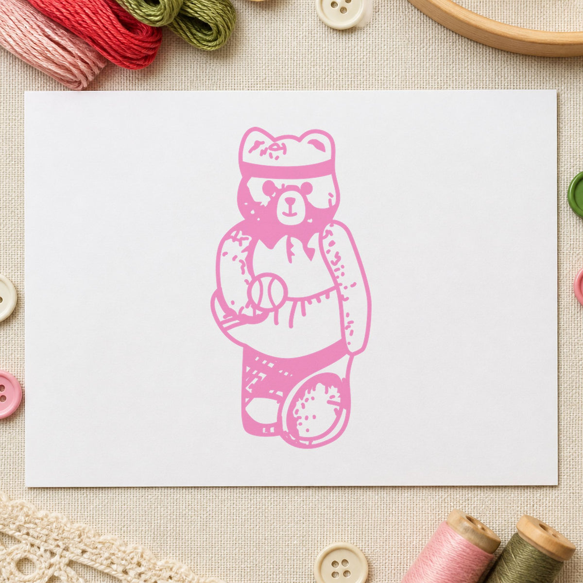Girl Tennis Bear Rubber Stamp impression in pink ink on white paper in a styled craft setting.