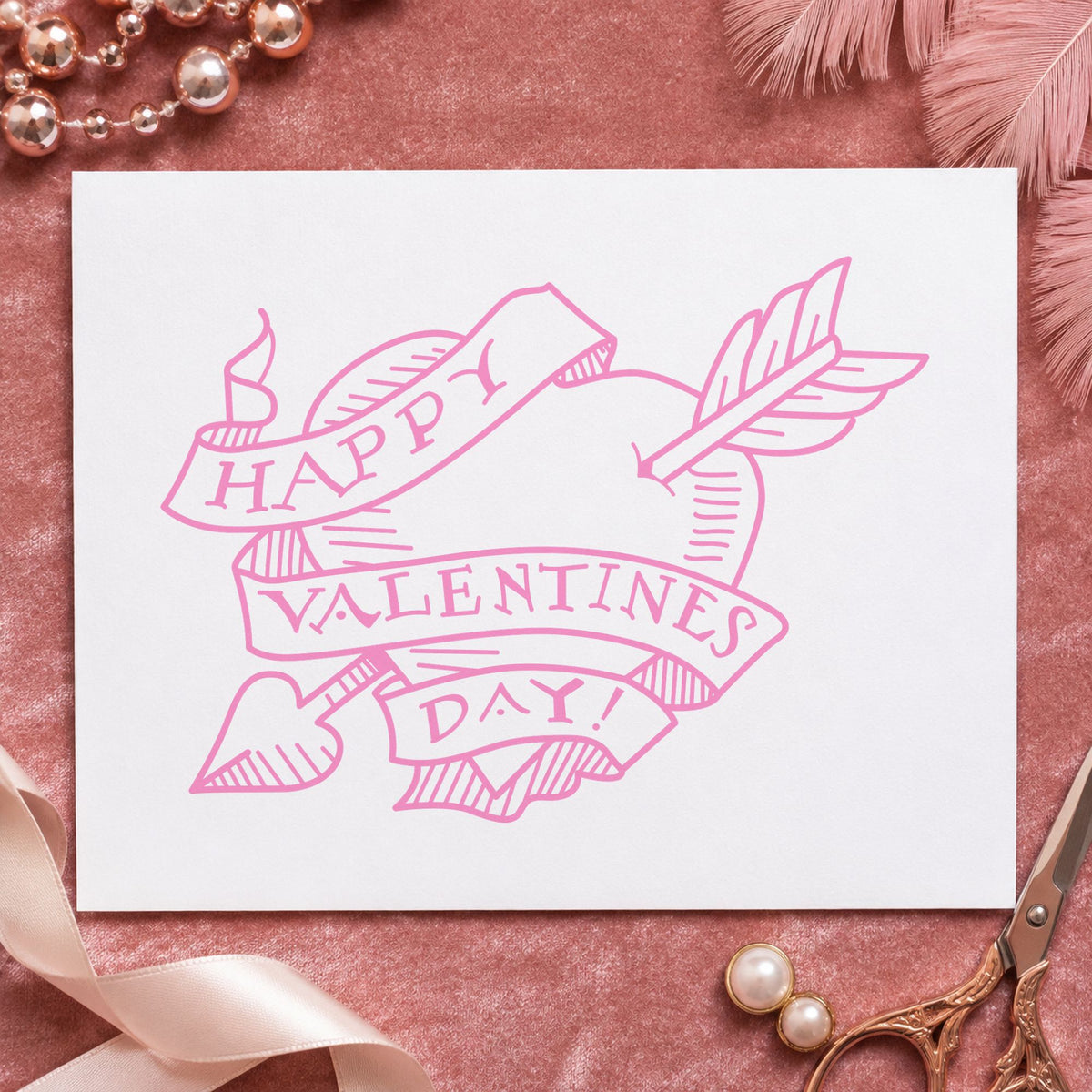 Valentine Heart with Arrow Rubber Stamp impression in pink ink on white paper in a styled craft setting.