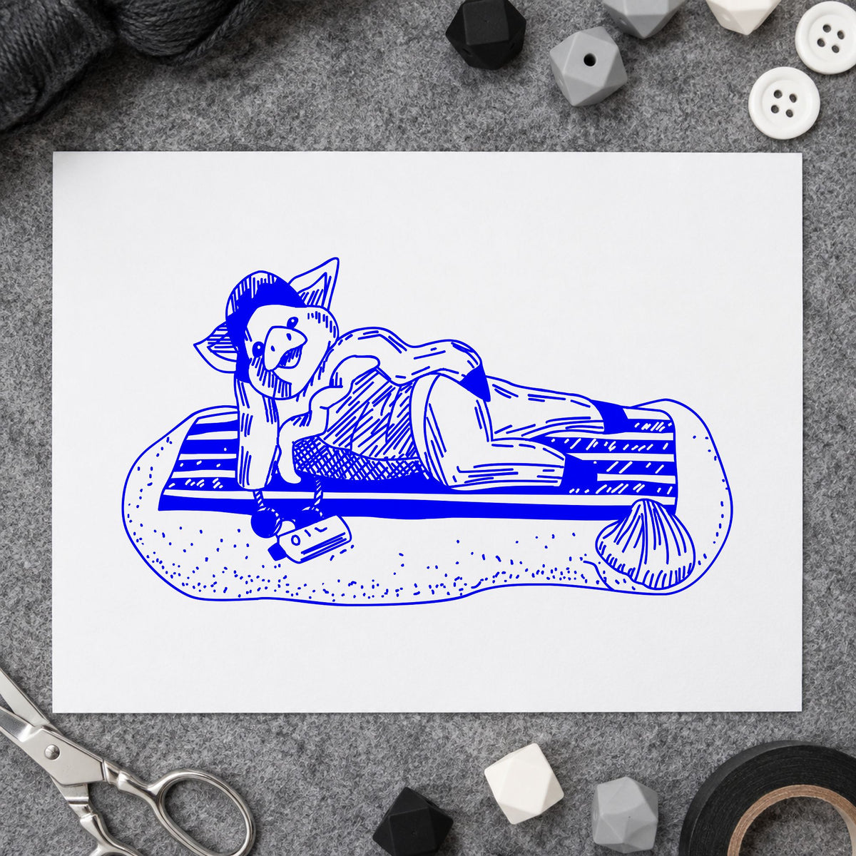 Blue summer scrapbook stamp impression featuring the pig on beach blanket design on white paper.