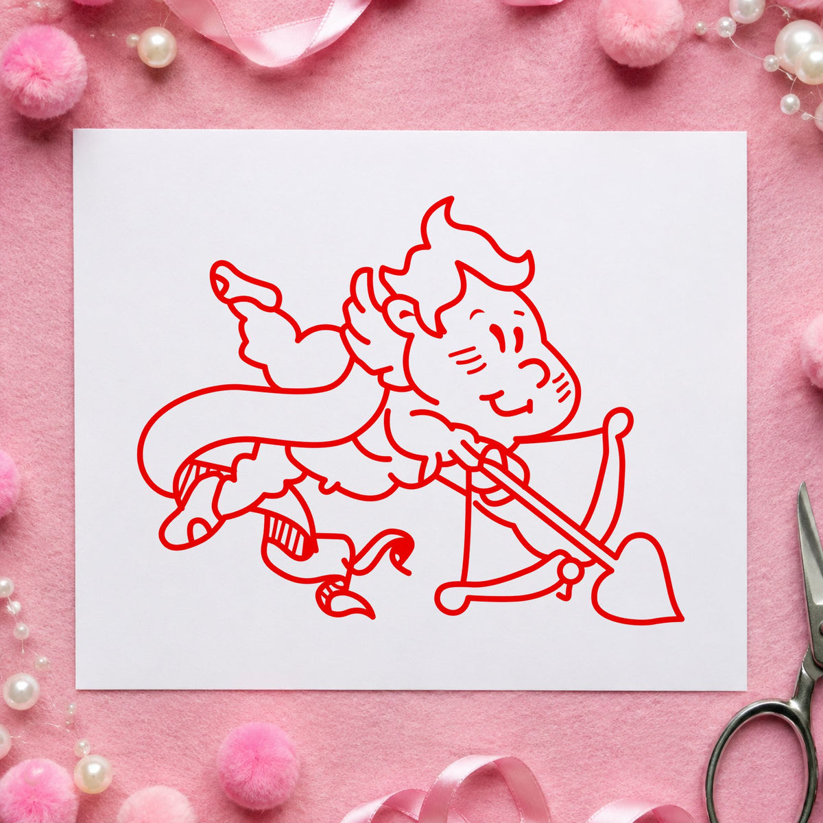 Cupid Shooting Heart Arrow Rubber Stamp impression in red ink on white paper in a styled craft setting.