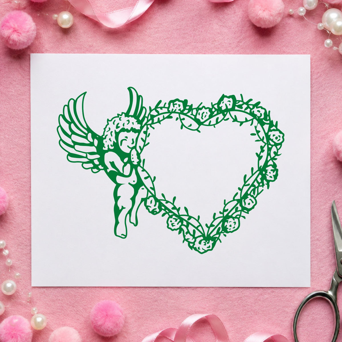 Cupid Holding Vine Heart Rubber Stamp impression in green ink on white paper in a styled craft setting.