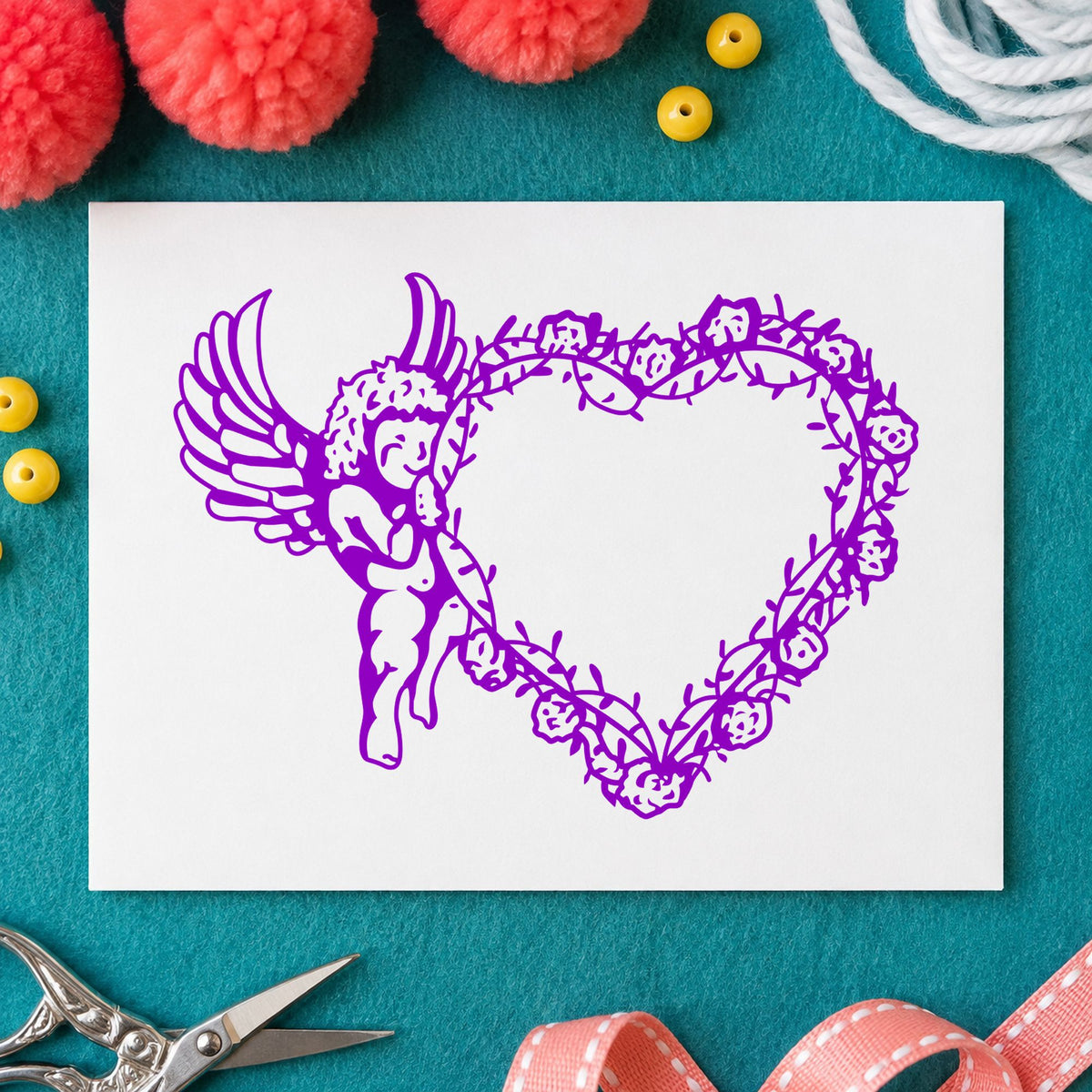 Cupid Holding Vine Heart Rubber Stamp impression in purple ink on white paper in a styled craft setting.