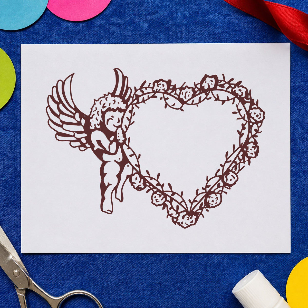 Cupid Holding Vine Heart Rubber Stamp impression in brown ink on white paper in a styled craft setting.