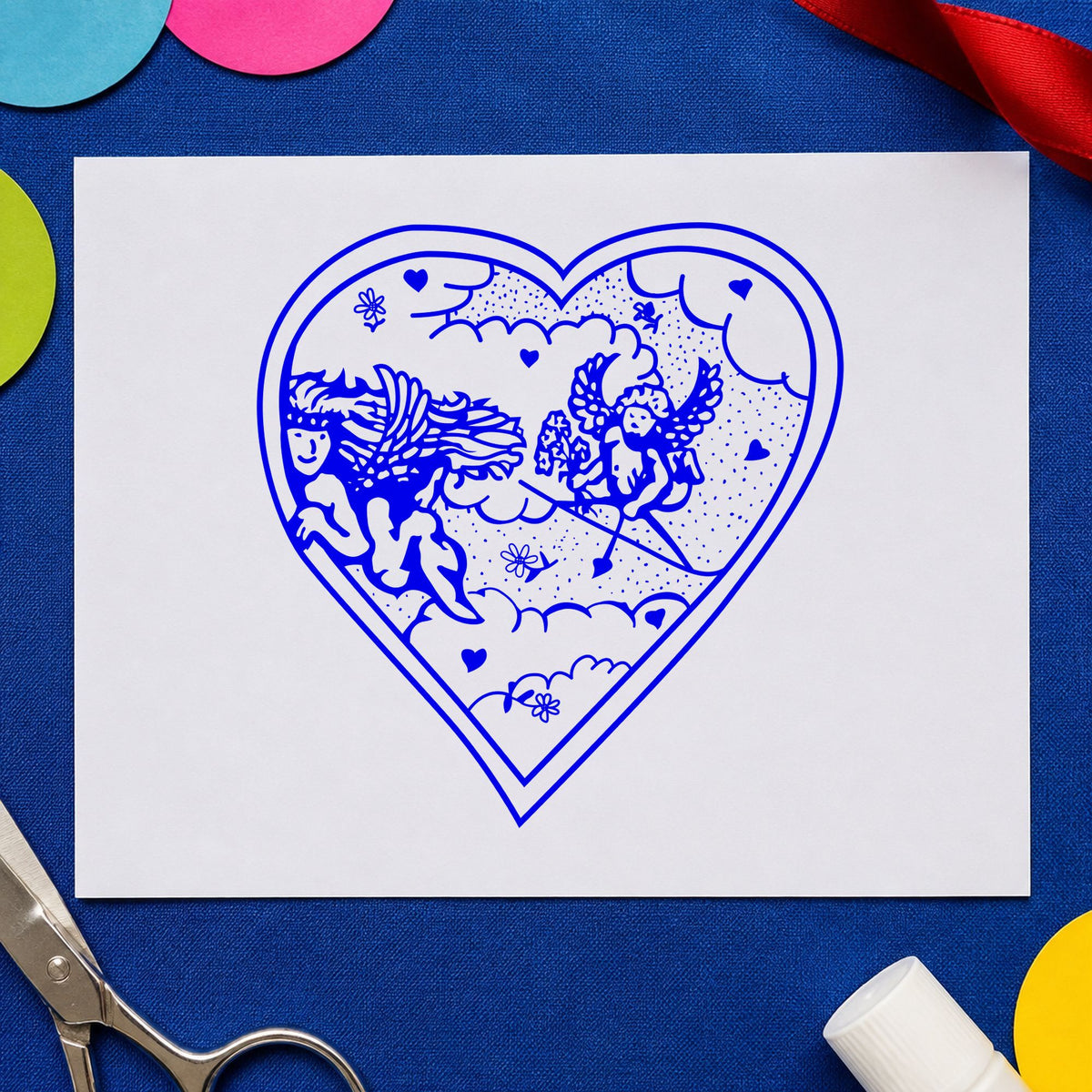 Heart with Two Cupids Rubber Stamp impression in blue ink on white paper in a styled craft setting.