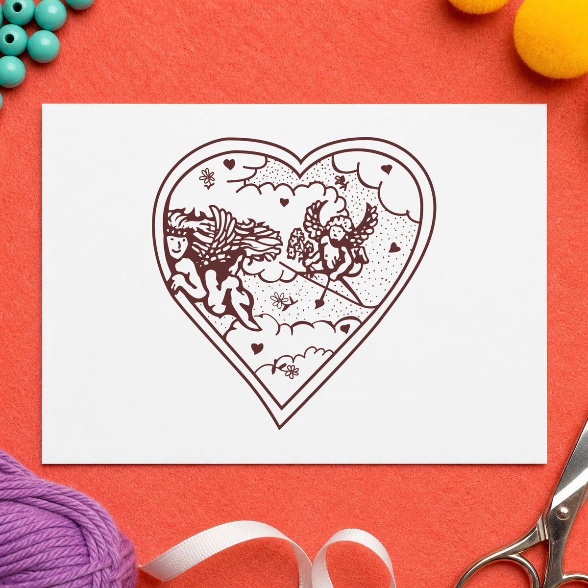 Heart with Two Cupids Rubber Stamp impression in brown ink on white paper in a styled craft setting.