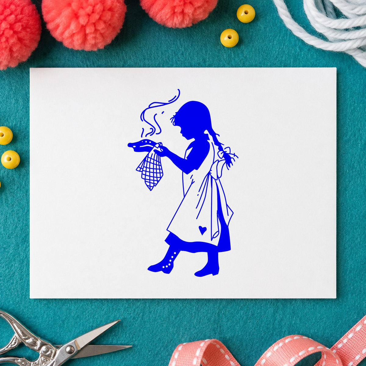 Girl Serving Pie Rubber Stamp impression in blue ink on white paper in a styled craft setting.