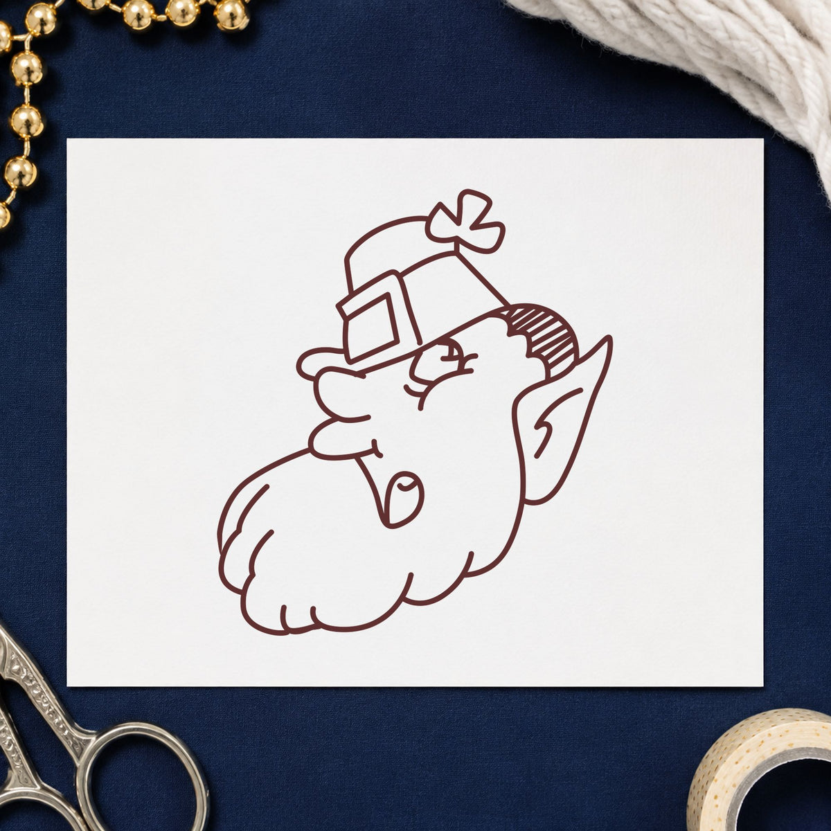 Leprechaun Head with Shamrock Hat Rubber Stamp impression in brown ink on white paper in a styled craft setting.