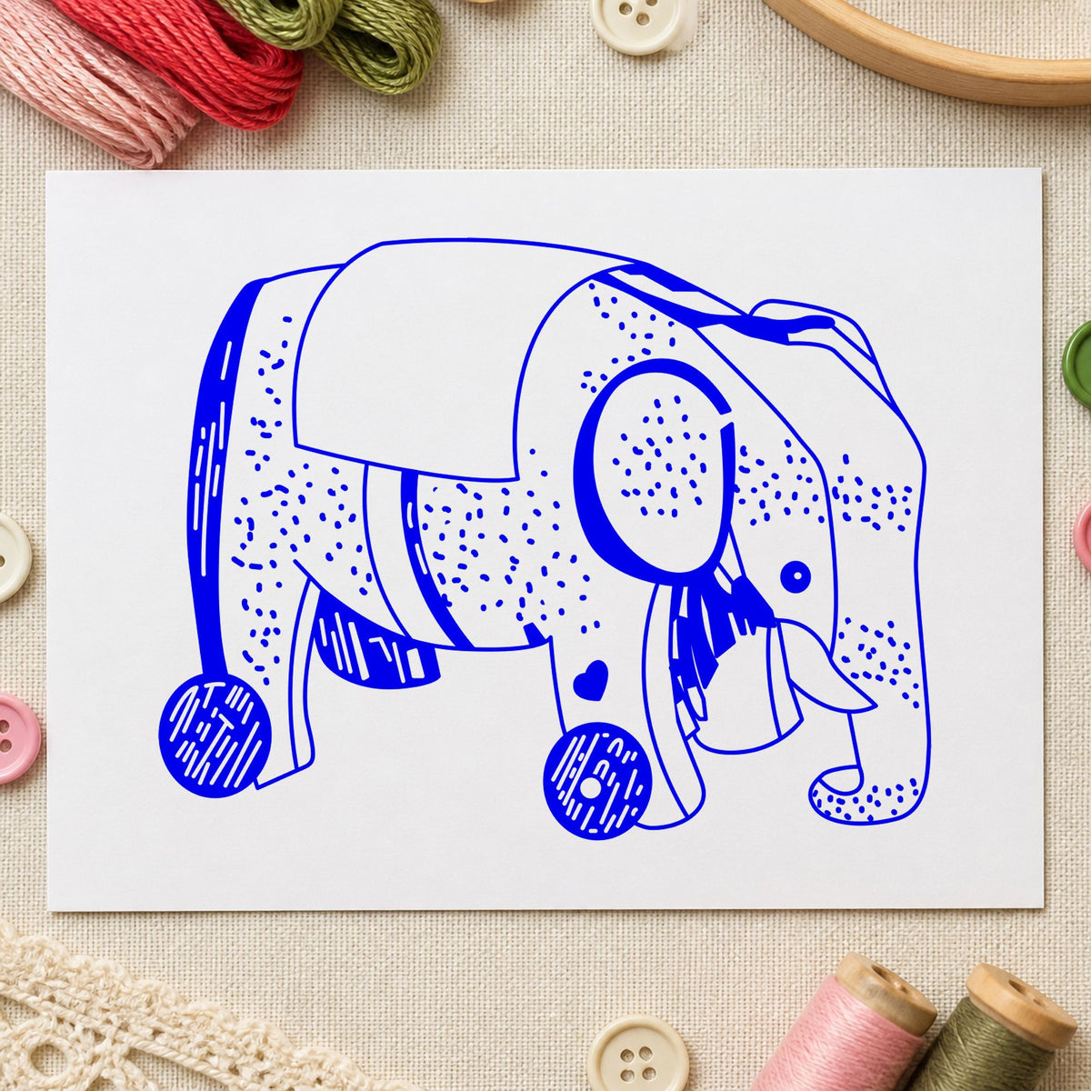 Blue nursery scrapbook stamp impression featuring the wheeled elephant toy design on white paper.
