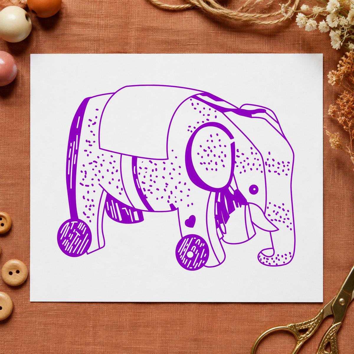 Wheeled Elephant Toy Rubber Stamp impression in purple ink on white paper in a styled craft setting.