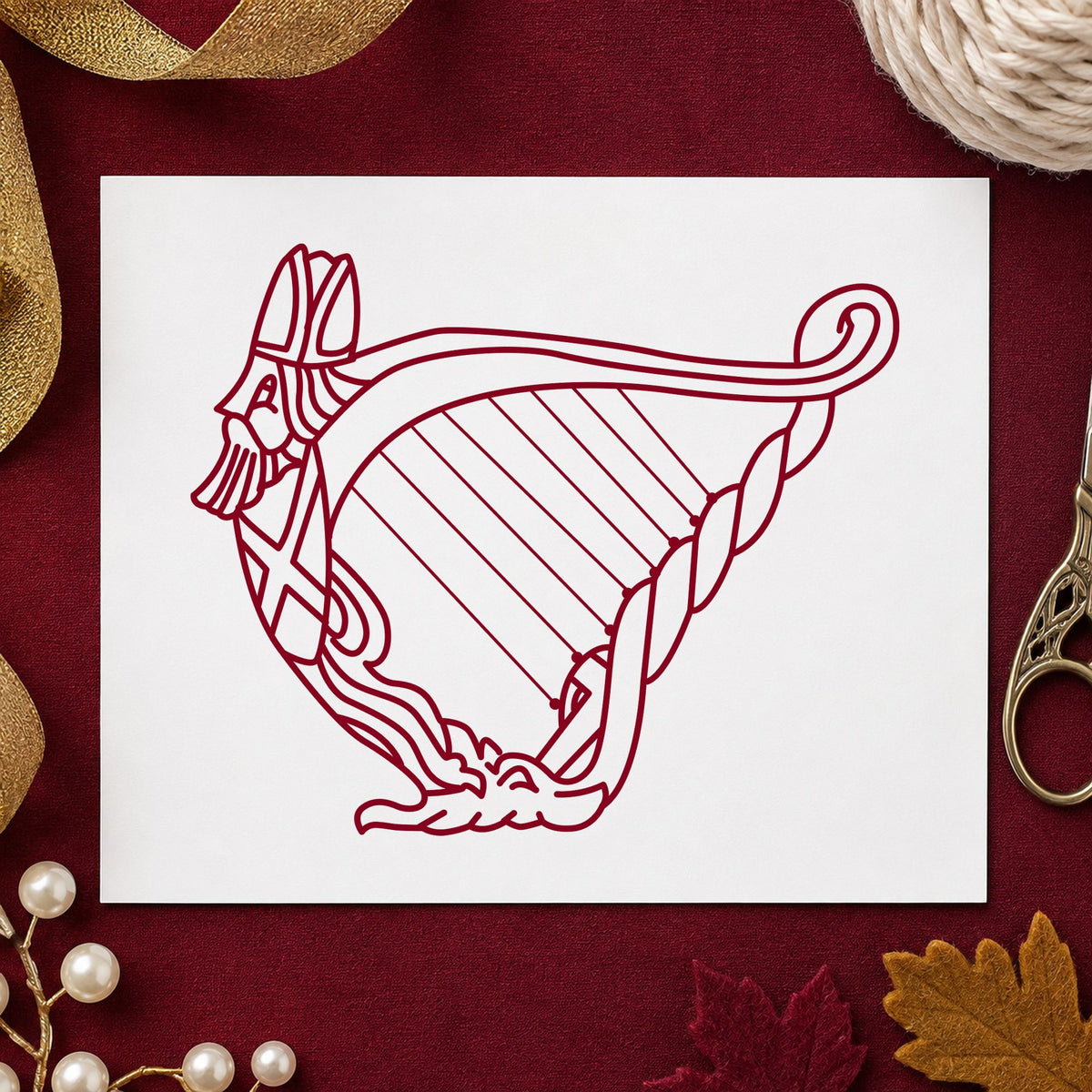 Decorative Harp Rubber Stamp impression in burgundy ink on white paper in a styled craft setting.