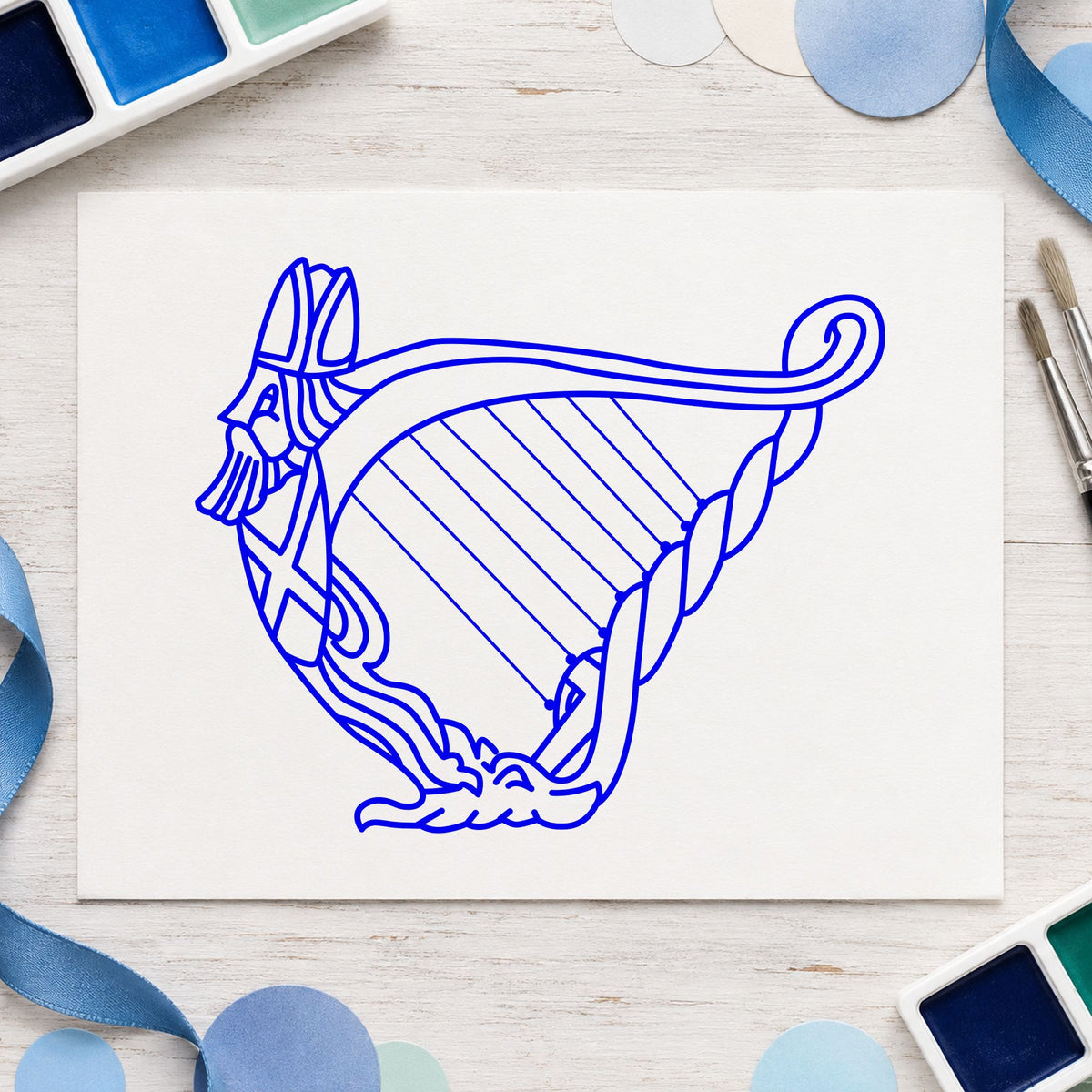 Blue musical instrument stamp impression featuring the decorative harp design on white paper.