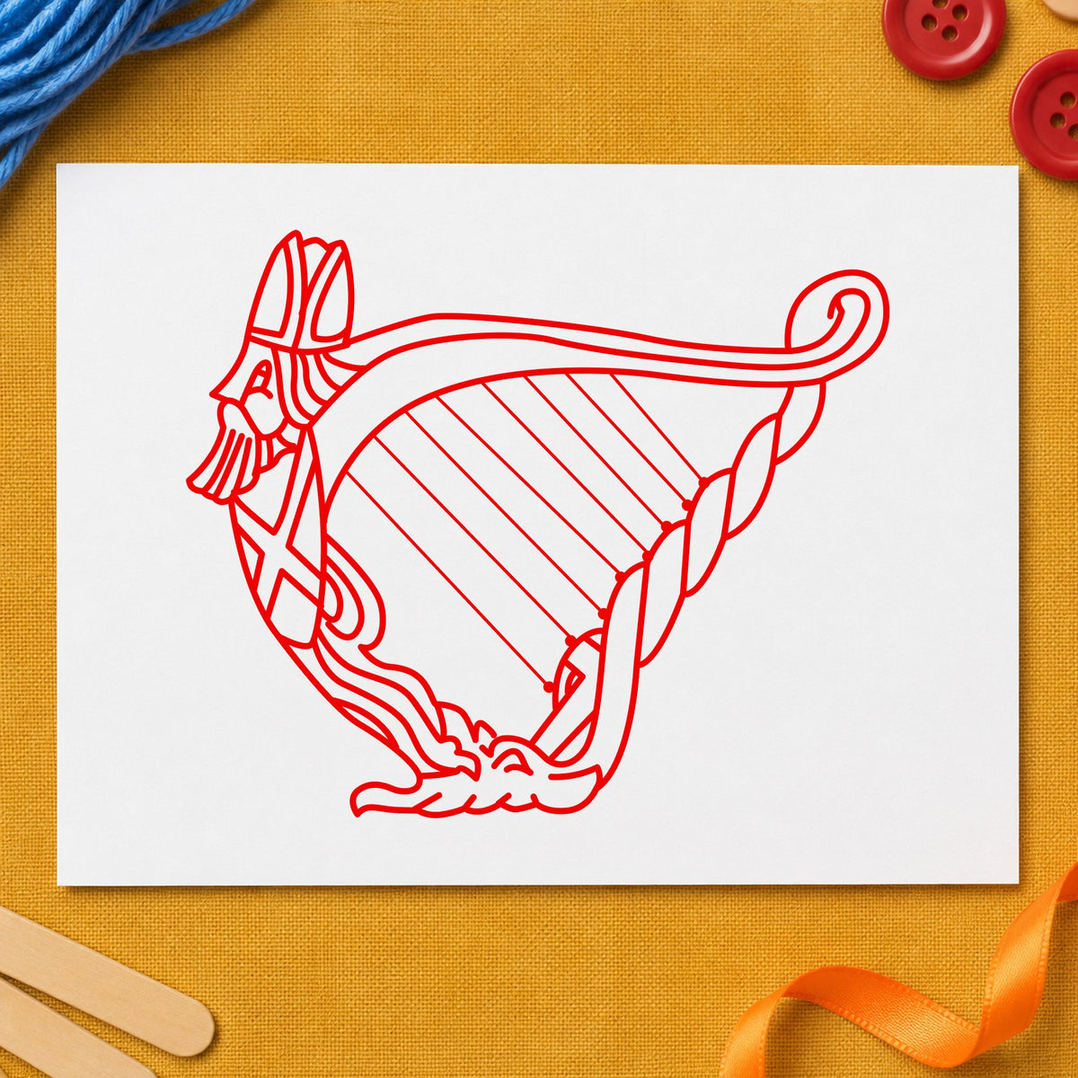 Decorative Harp Rubber Stamp impression in red ink on white paper in a styled craft setting.
