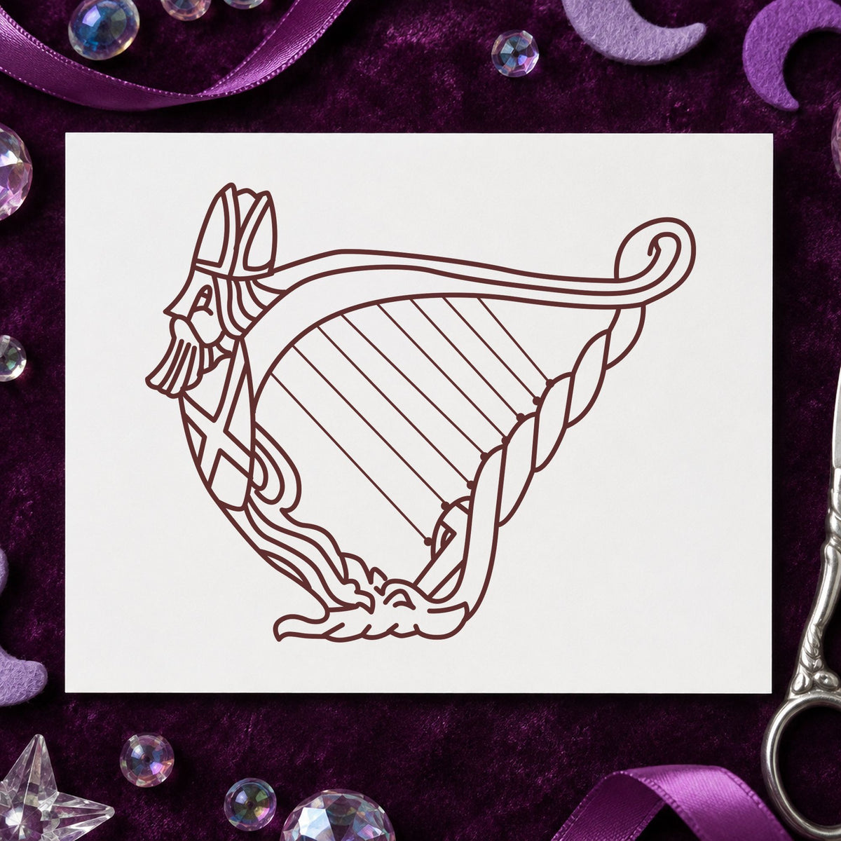 Decorative Harp Rubber Stamp impression in brown ink on white paper in a styled craft setting.