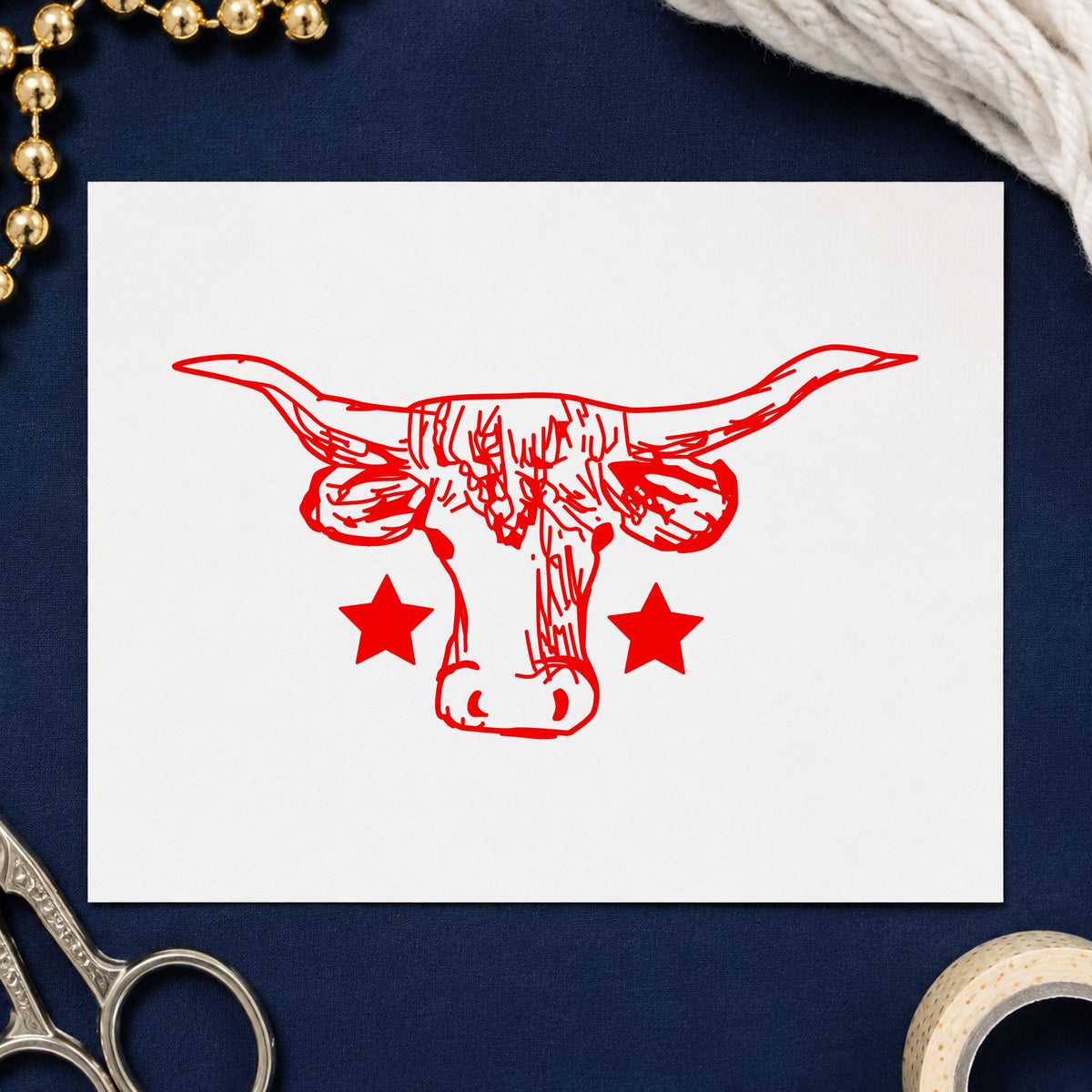 Lone Star Longhorn Bull Rubber Stamp impression in red ink on white paper in a styled craft setting.
