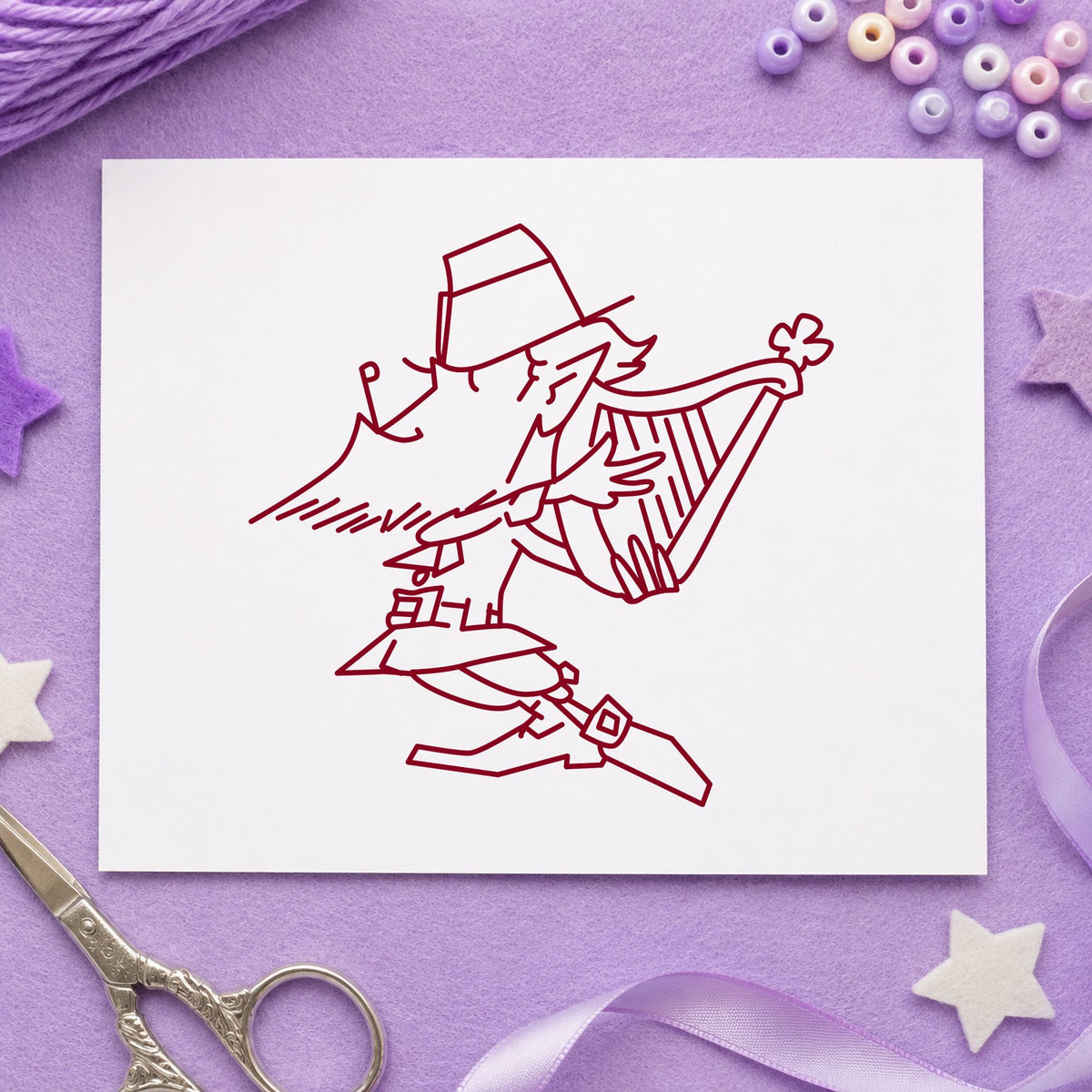 Leprechaun Playing Harp Rubber Stamp impression in burgundy ink on white paper in a styled craft setting.