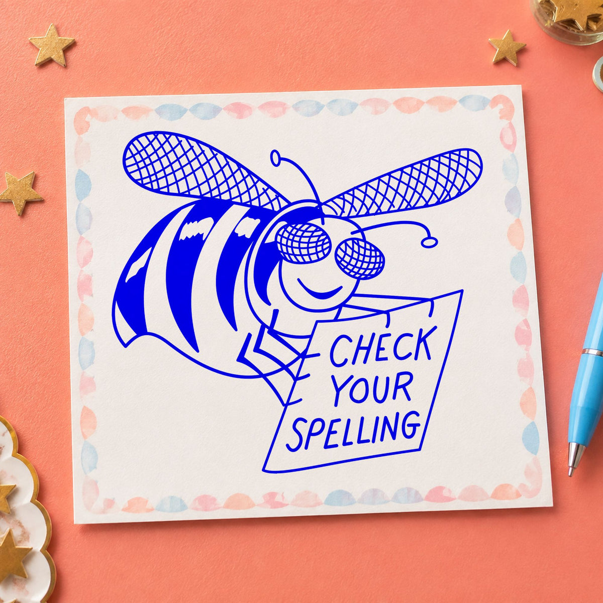 Blue teacher bee stamp impression featuring the check your spelling bee design on white paper.