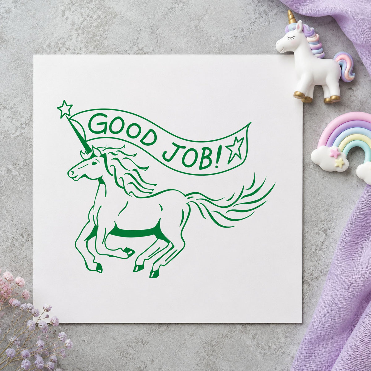 Good Job Unicorn Rubber Stamp impression in green ink on white paper in a styled craft setting.