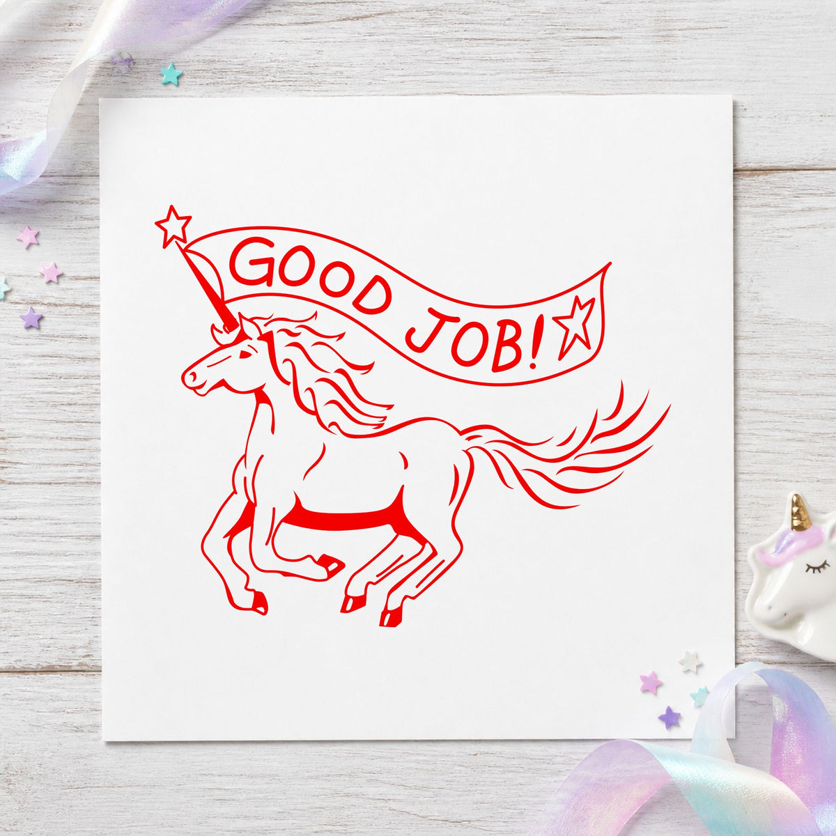 Good Job Unicorn Rubber Stamp impression in red ink on white paper in a styled craft setting.