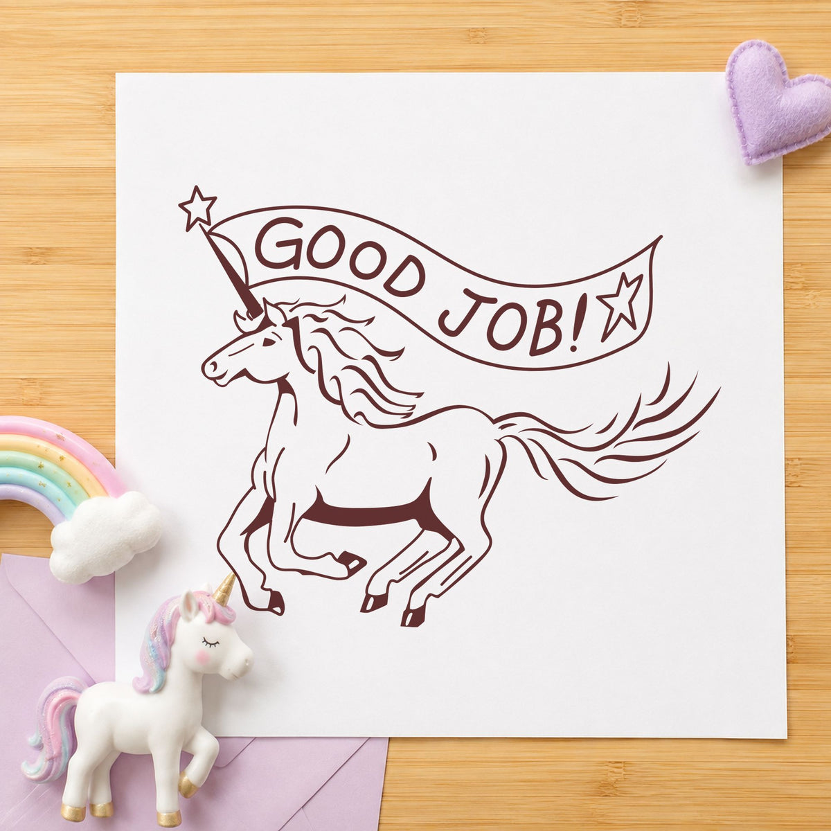 Good Job Unicorn Rubber Stamp impression in brown ink on white paper in a styled craft setting.